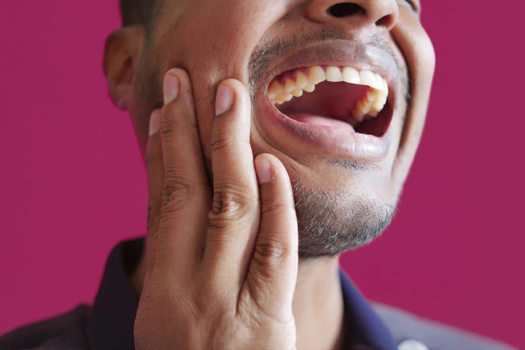 tooth ache Man with painful toothache holding face